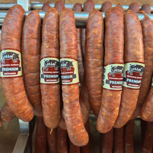 Longanizas Premium Serrot de cerca, con su etiqueta, en la sala de ahumado