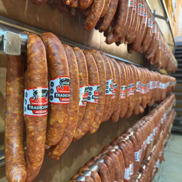 Longanizas Tradicional Serrot recién ahumadas colgando en la sala de ahumado